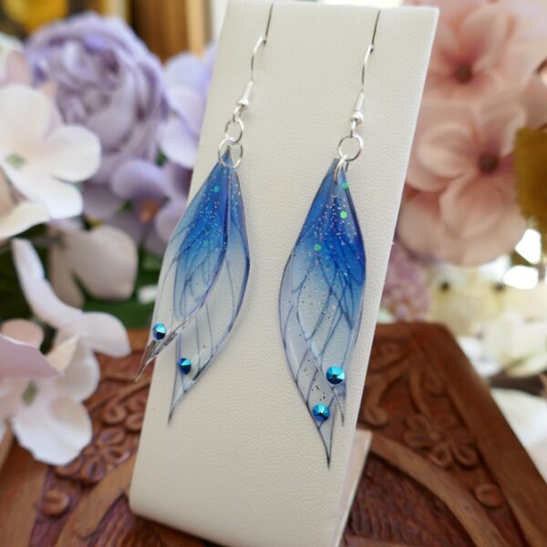 Boucles d'oreilles ailes de fée bleus artisanales en résine transparente et en argent 925