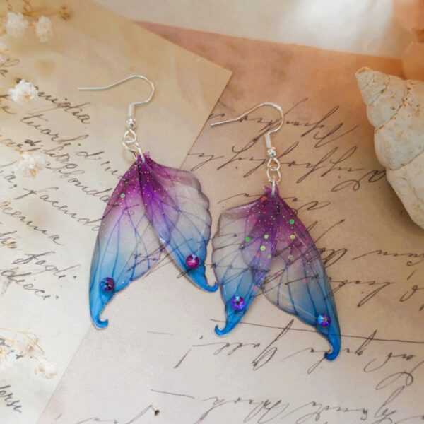 Boucles d'oreilles argent 925 ailes de fée artisanales, sirène, aux nuances de bleu eu de violet des profondeurs abyssales, saupoudrées de poussière enchantées, recouvertes de résine transparente de haute qualité et flexible.
