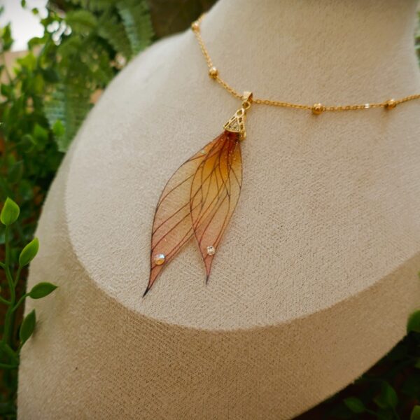 Collier ailes de fée artisanal aux inspirations elfiques aux nuances de rose, doré et brun, en résine transparente et en plaqué or
