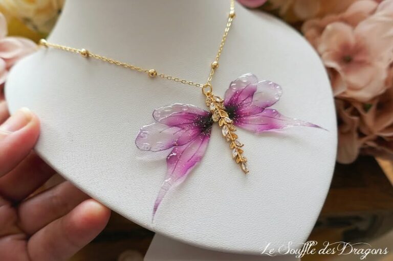 Collier réalisée artisanalement avec des ailes de fée en résine, irisée de paillettes enchantées et montée sur du plaqué or